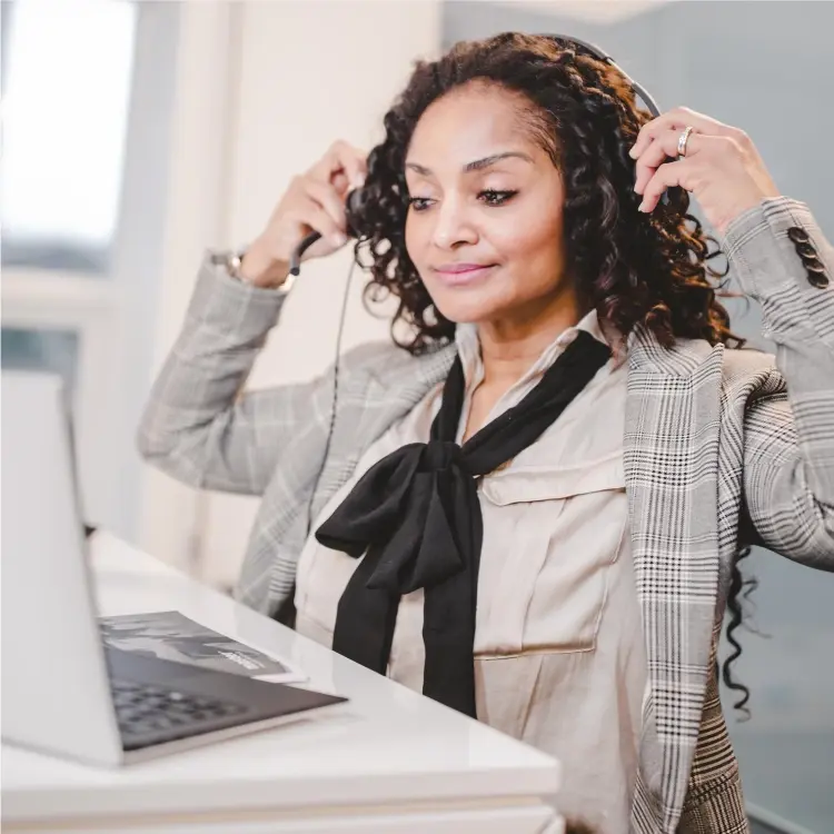 Mujer del equipo de Master se prepara para una reunión online poniéndose los auriculares